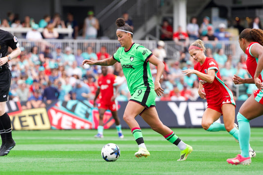 Amanda Gutierres dribbles the ball past KC Current players