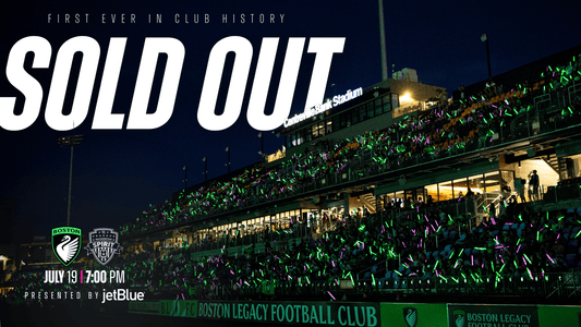 Boston Legacy FC announces their first ever sold-out match in club history — Boston Legacy FC vs. Washington Spirit, July 19 at 7:00 PM at Centreville Bank Stadium, presented by JetBlue. A packed stadium glows with green and pink light sticks at night.